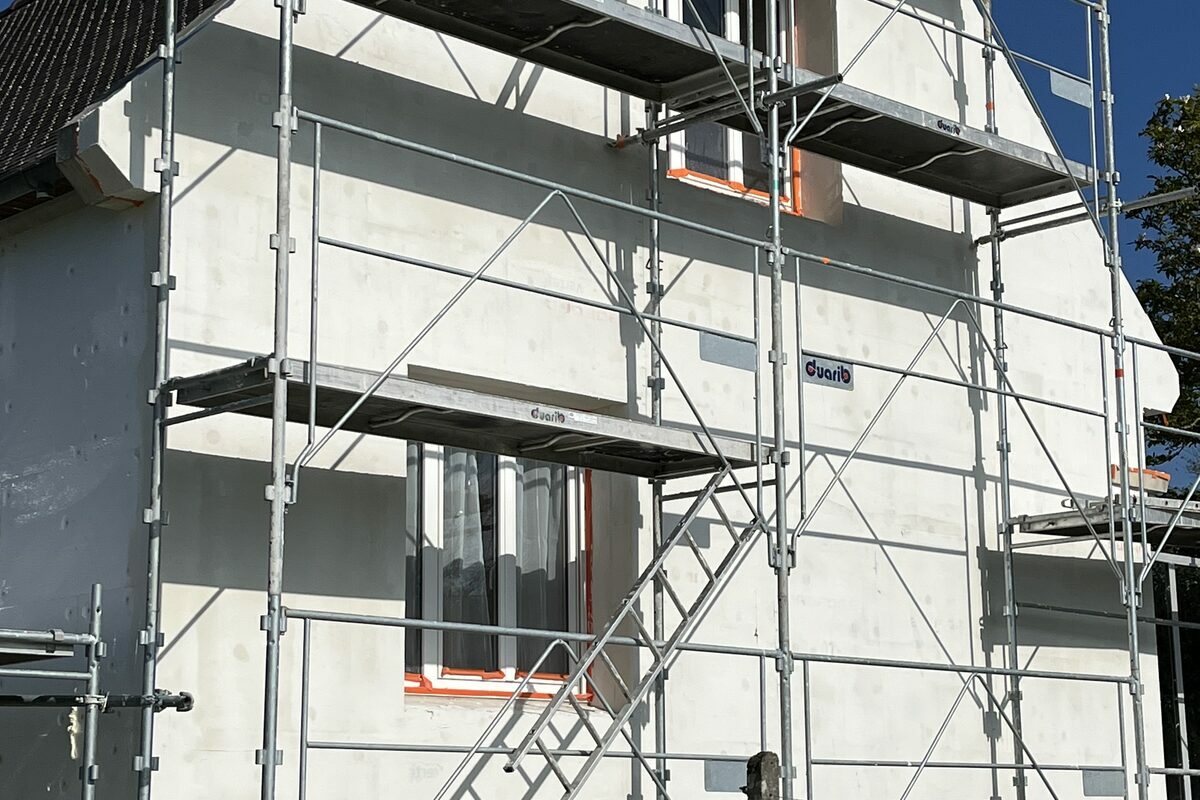 Maison sous échafaudage pendant un chantier d'isolation par l'extérieur