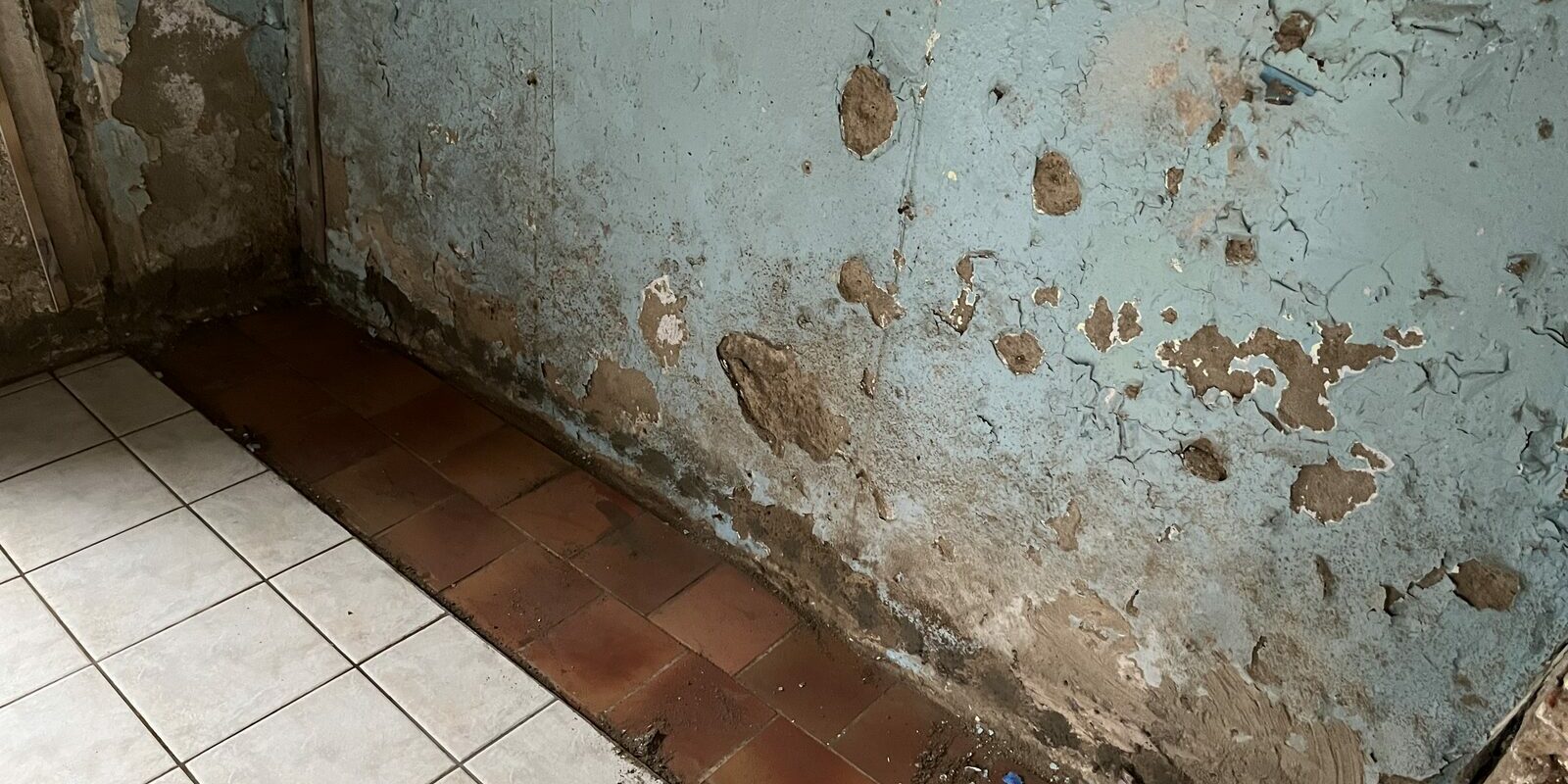 Pièce ancienne aux murs dégradés par l'humidité, peintures écaillées