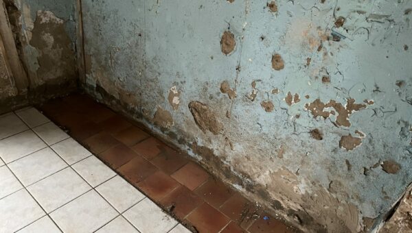 Pièce ancienne aux murs dégradés par l'humidité, peintures écaillées