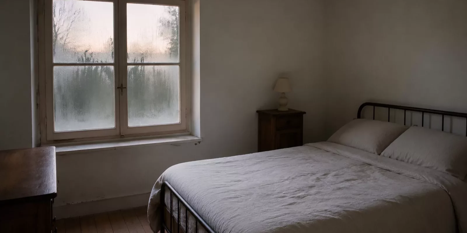 Chambre d'une maison ancienne avec de la condensation sur la fenêtre au petit matin