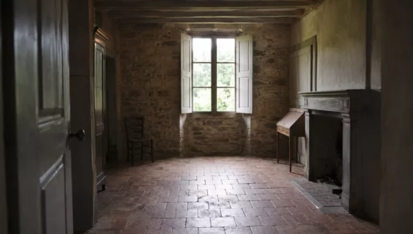 Intérieur confiné d'une maison ancienne aux murs de pierre et au sol en tomettes